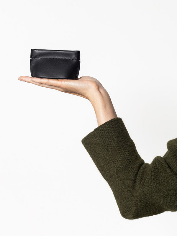 Building Block Coin Dumpling in Black leather displayed in hand to show its compact 6 × 9 × 4.5 cm size.