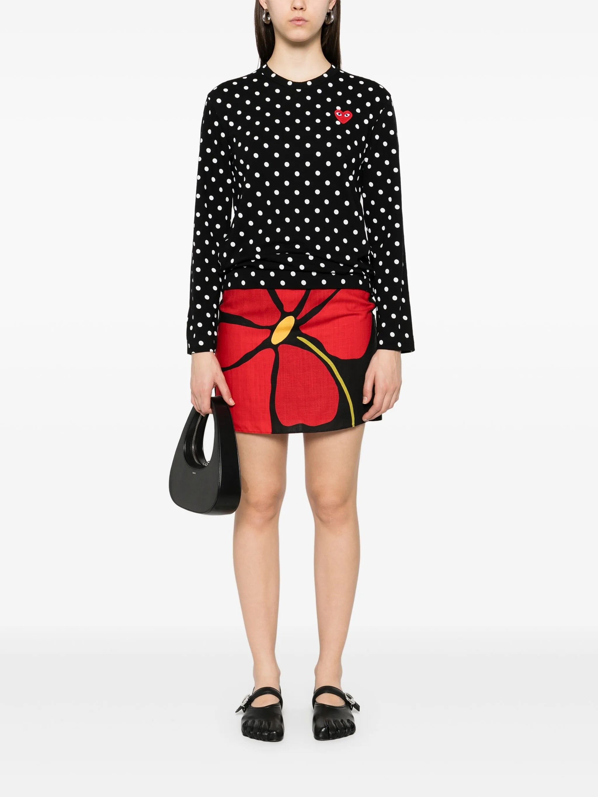 Model wearing Comme des Garçons Play Unisex Polka Dot Long Sleeve Shirt in black with white dots, long sleeves and relaxed fit