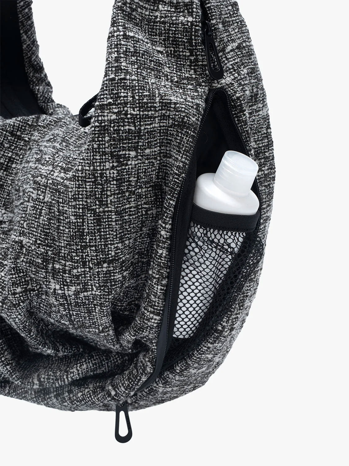 Close-up of Côte & Ciel Hyco S Tweed in Black & Cream showing the textured fabric, side zipper and internal mesh pocket