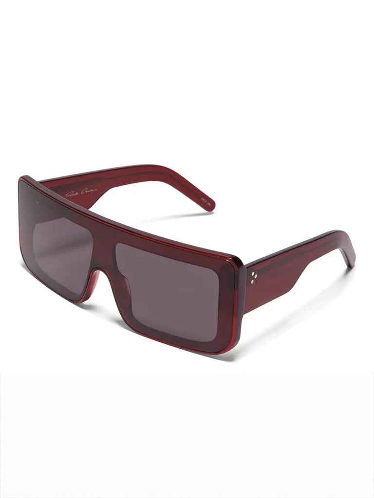 Three-quarter view of Rick Owens Documenta Sunglasses showing blood red acetate frame, wide arms and oversized rectangular silhouette