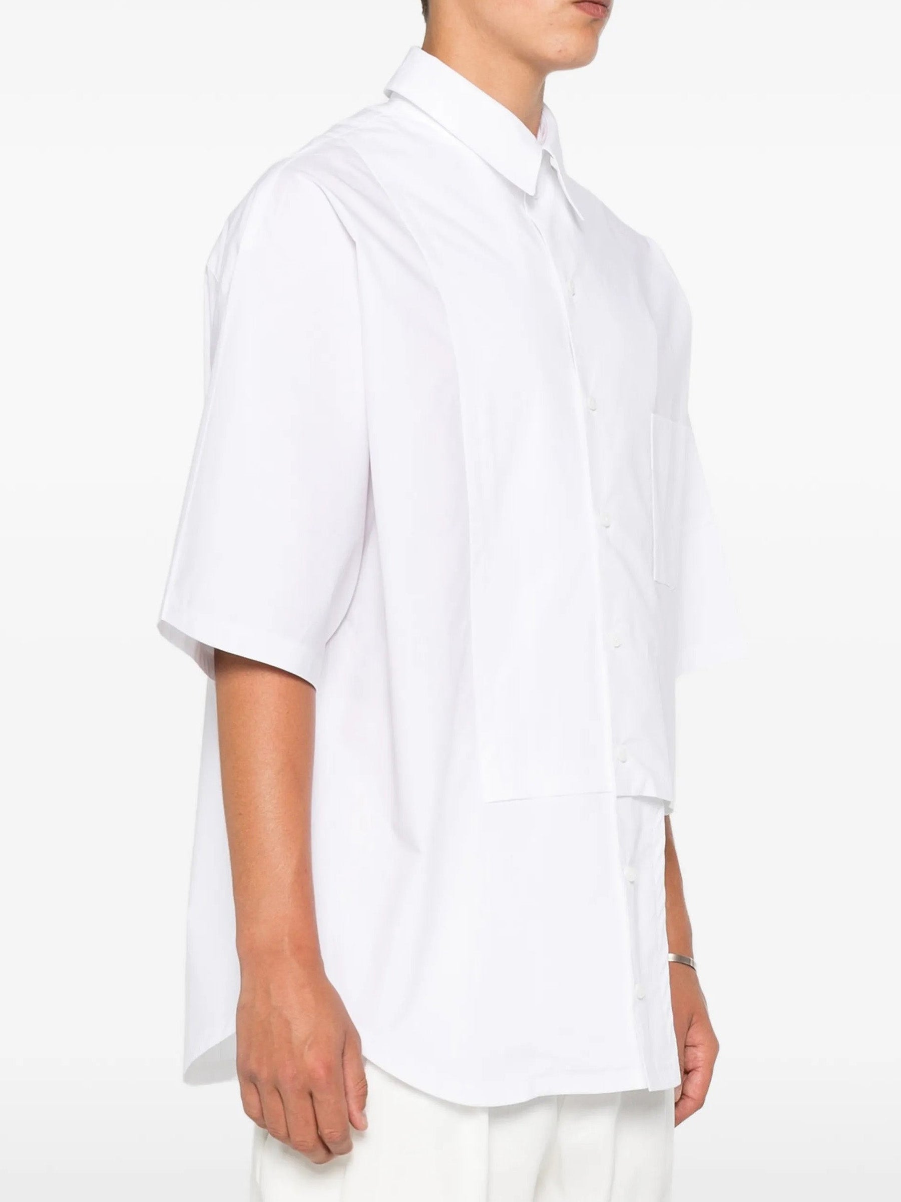 House Of The Very Islands Harley Asymmetric Shirt in White - side view on model showing asymmetric seam and short sleeve detail