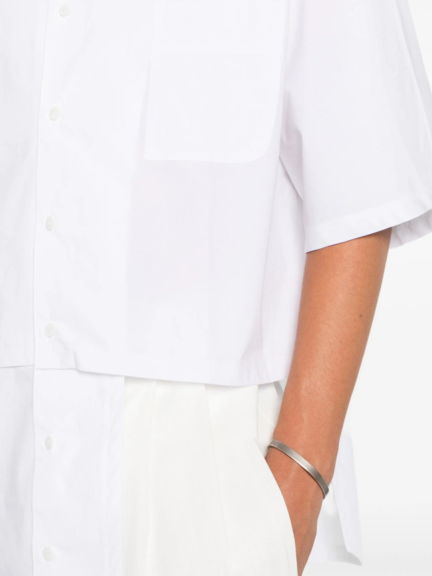 House Of The Very Islands Harley Asymmetric Shirt in White - detail view showing chest patch pocket and asymmetric seam construction