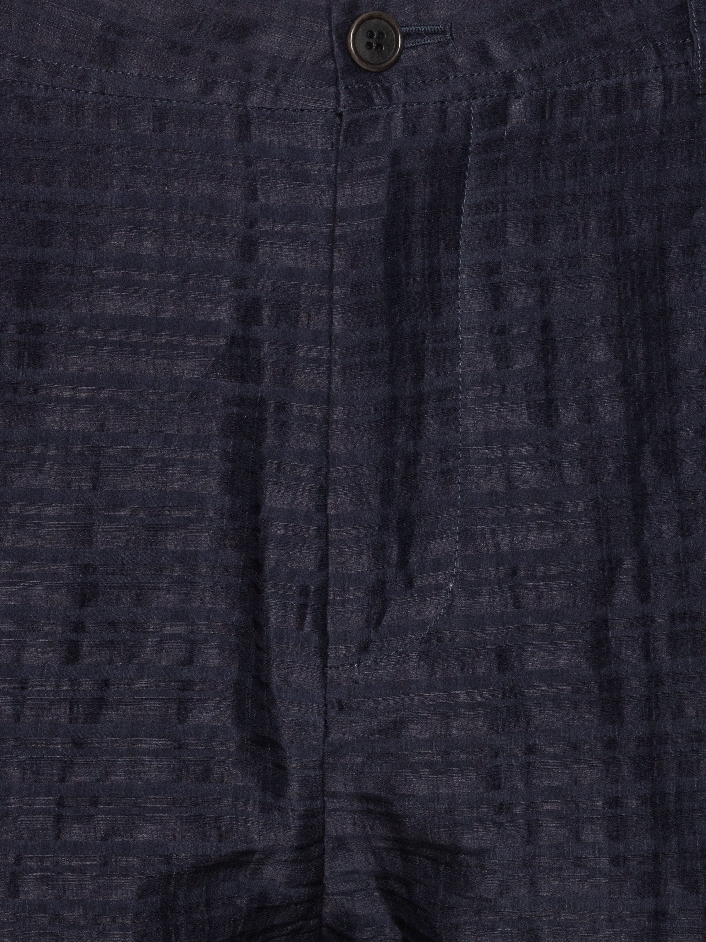 Close-up shot of the Artist Pants in navy from Henrik Vibskov Spring/Summer 2026 Studio Collection, showing the front button and zipper closure, waistband stitching, and pocket detailing.