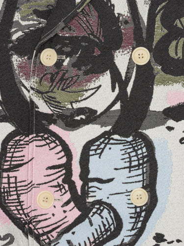 Close-up of the Care Coat in Carrots from Henrik Vibskov Spring/Summer 2026 Studio Collection, highlighting the multicoloured carrot print, textured fabric, and double-breasted button details.