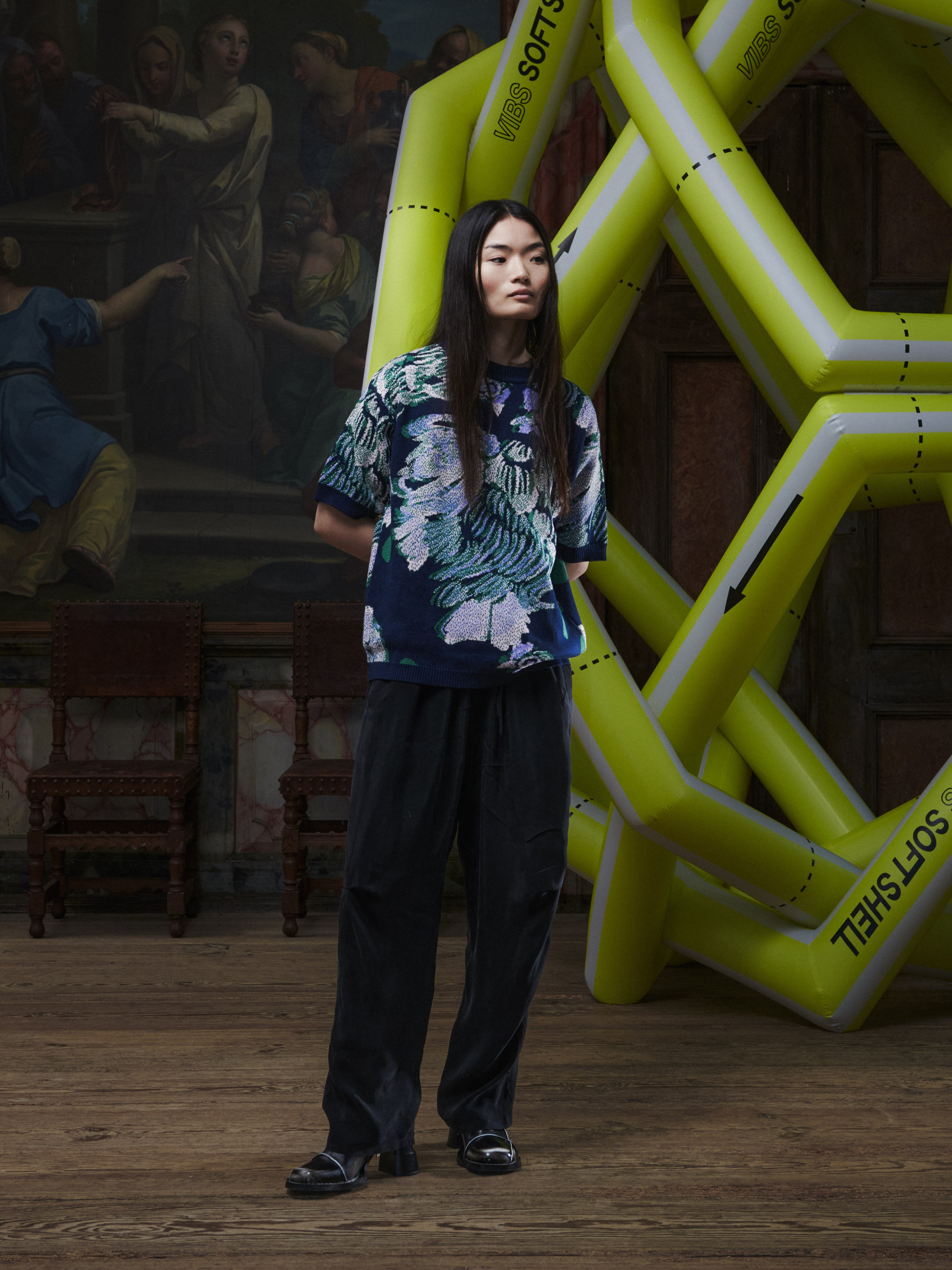 Front view of a female model wearing the Chicken T Knit in Chicken Navy from Henrik Vibskov Spring/Summer 2026 Studio Collection, highlighting the chicken motif, crew neckline, and relaxed unisex fit.