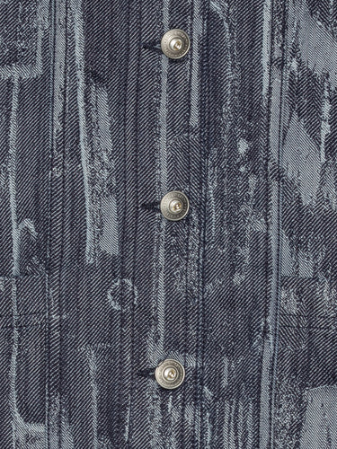Close-up of the Dial Denim Jacket showing the grey-blue denim texture, abstract pattern, and button detailing.