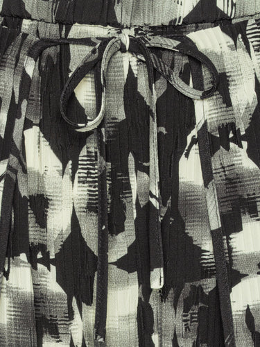 Close-up of the plissé texture and abstract bursting-eggs print on the pants.