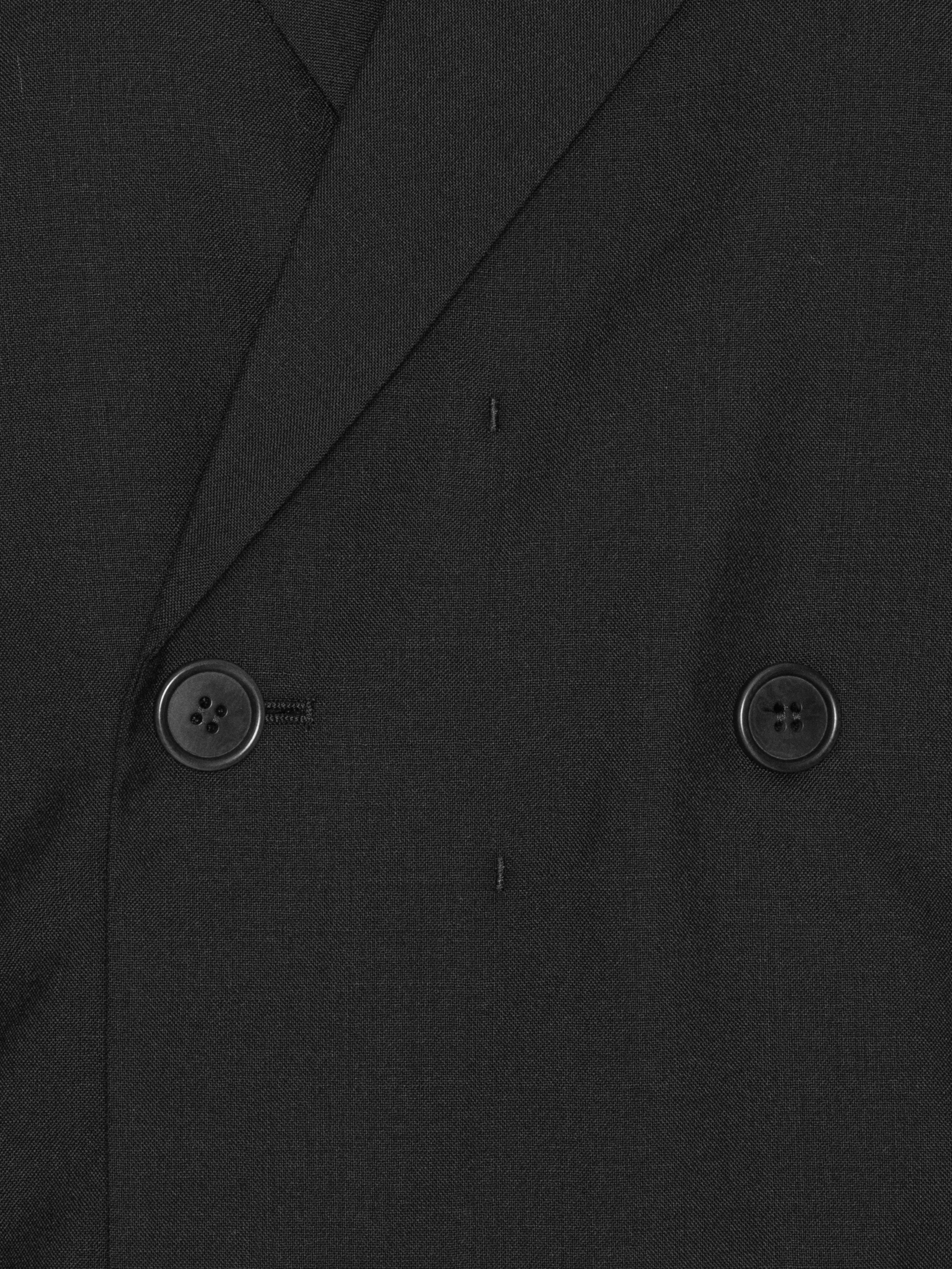Close-up of the Henrik Vibskov Lonely Sjacket in Tropical Wool, highlighting the layered blazer construction, button details, and wool texture.