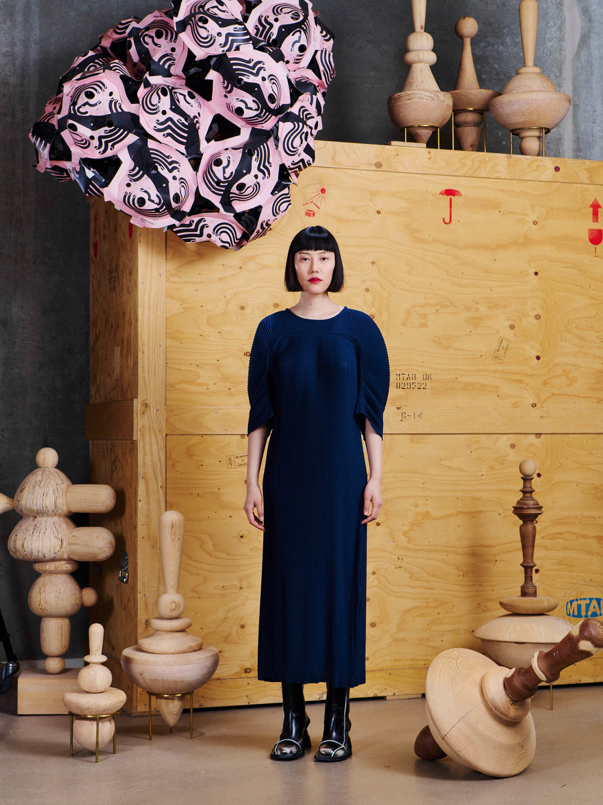 Model wearing the Henrik Vibskov Lupu Plisse Dress in Dress Blues from the front, showing the straight silhouette and voluminous pleated sleeves.