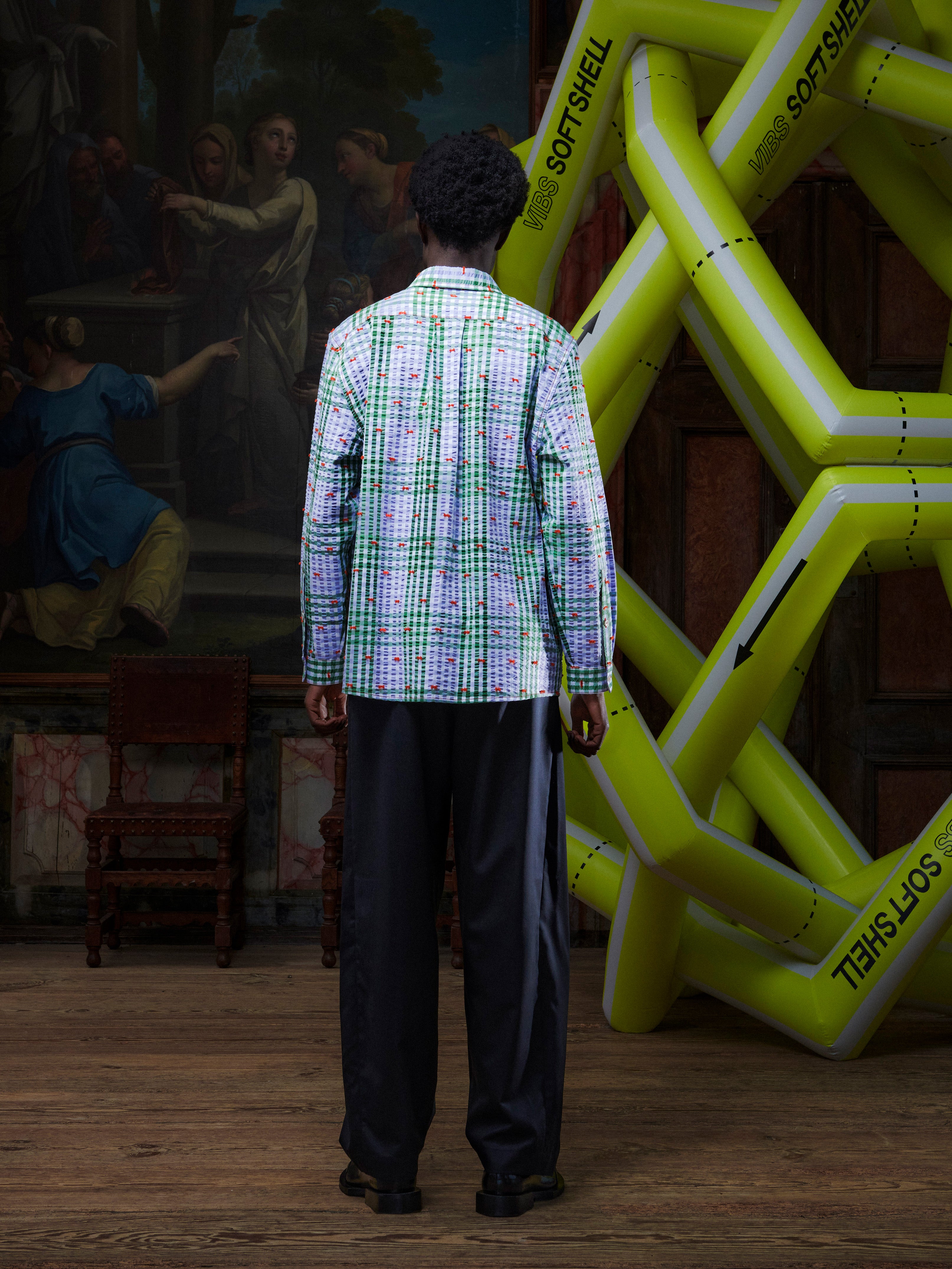 Model wearing the Henrik Vibskov New Blou Shirt in Checks Fillé, back view, showing the full purple and green check pattern and straight silhouette.