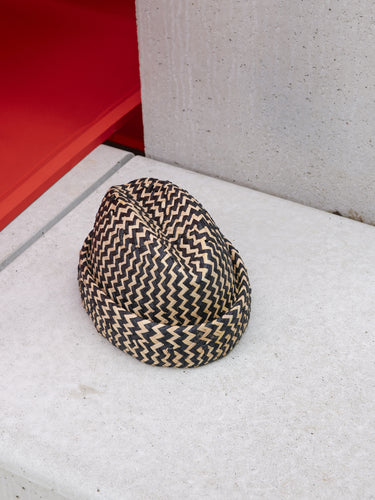 Newspaper Straw Hat in Black Natural Straw by Henrik Vibskov, angled front view showing black and natural chevron woven straw construction, dramatically gathered crown and rolled brim detail, Spring/Summer 2026 Key Collection