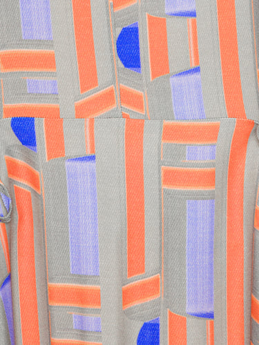 Close-up of a fabric with geometric pattern featuring orange, blue, and gray colors.