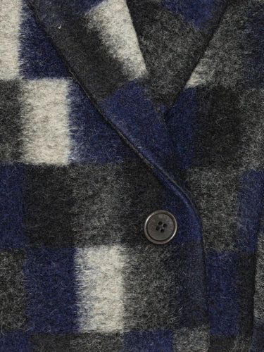 Close-up of a checkered fabric with a button, featuring blue, gray, and white colors.