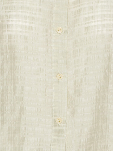 Close-up of a light-colored fabric with button details