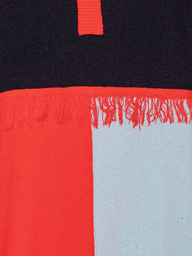 Close-up of color-blocked sweater with red, black, and light blue sections.