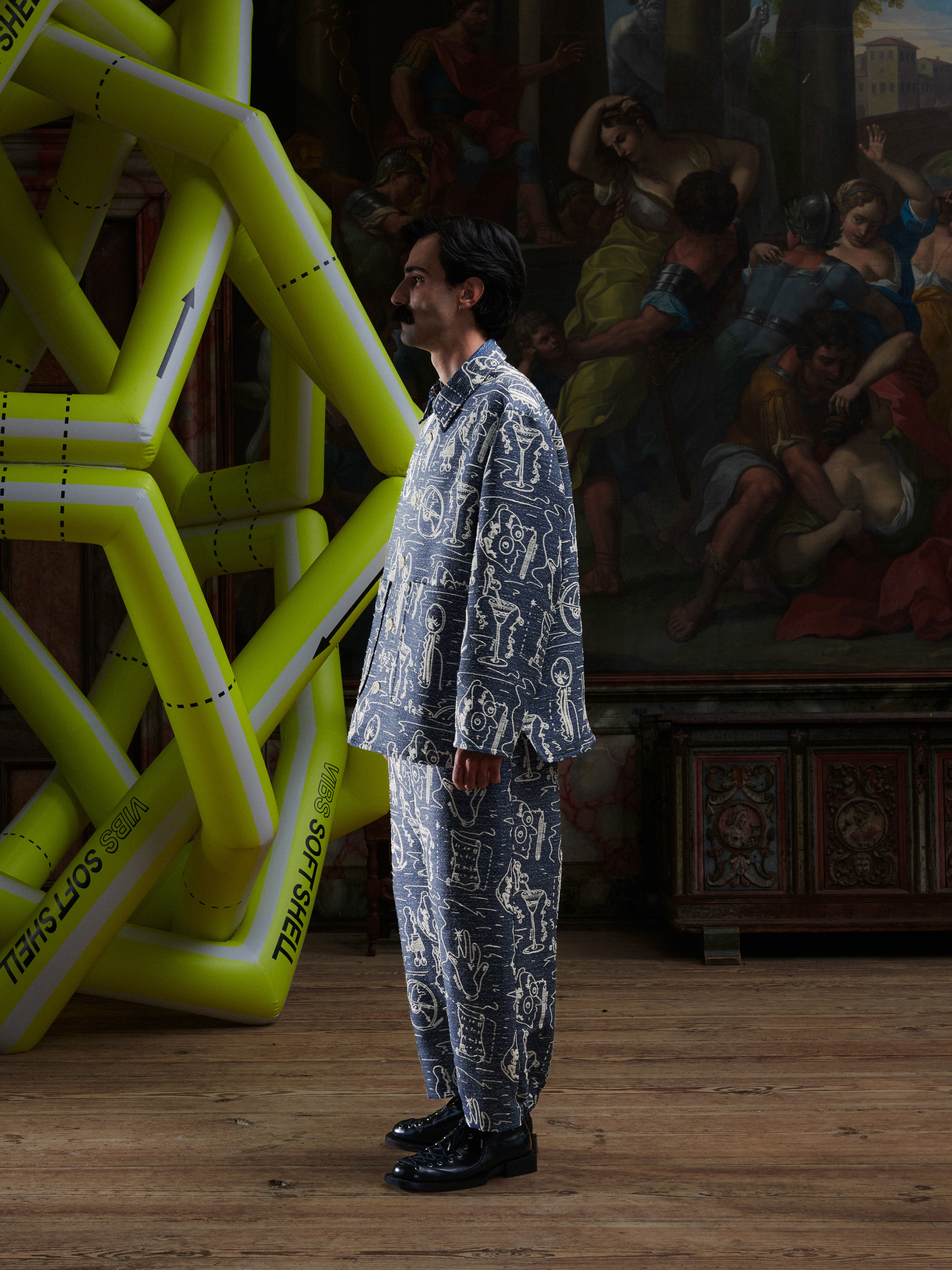 Side view of model wearing the Wheel jacket in a doodle print by Henrik Vibskov
