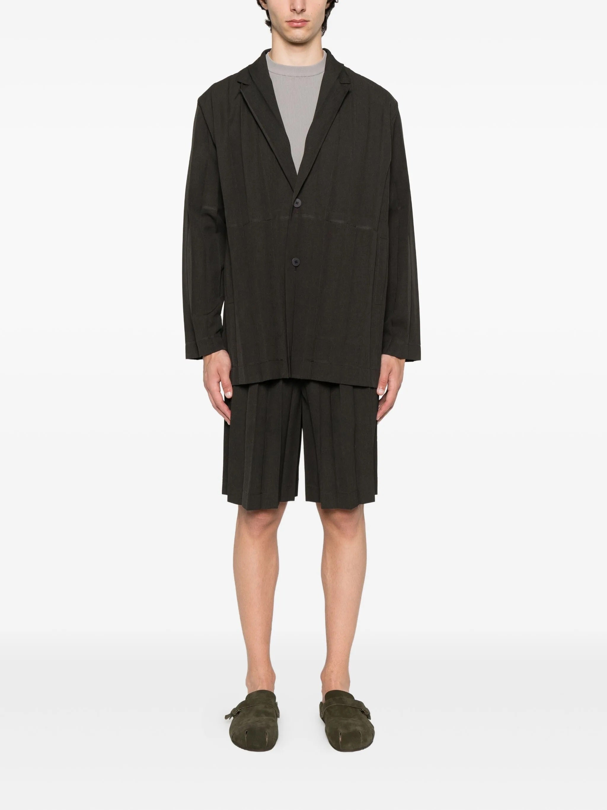 Person wearing a dark brown blazer and shorts on a white background