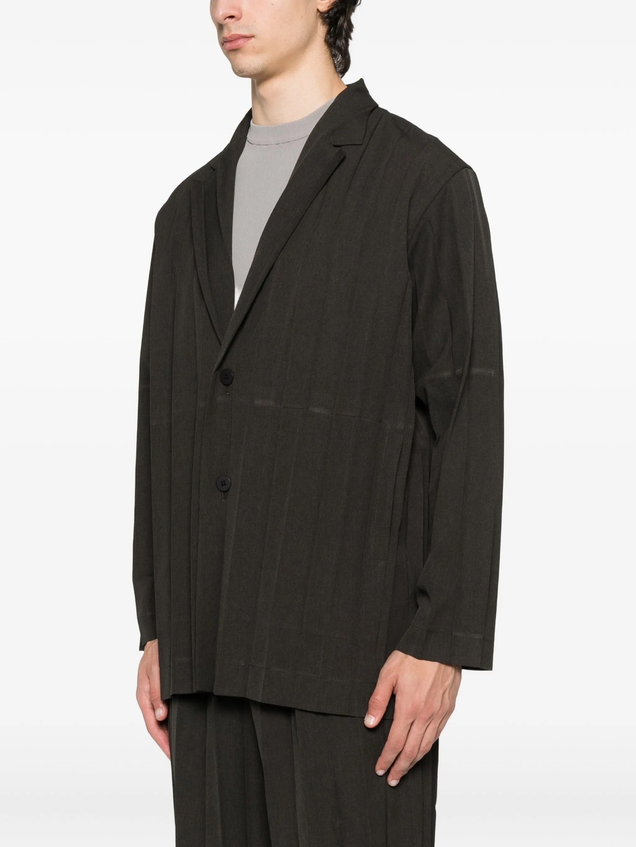 Person wearing a dark brown blazer and shorts on a white background