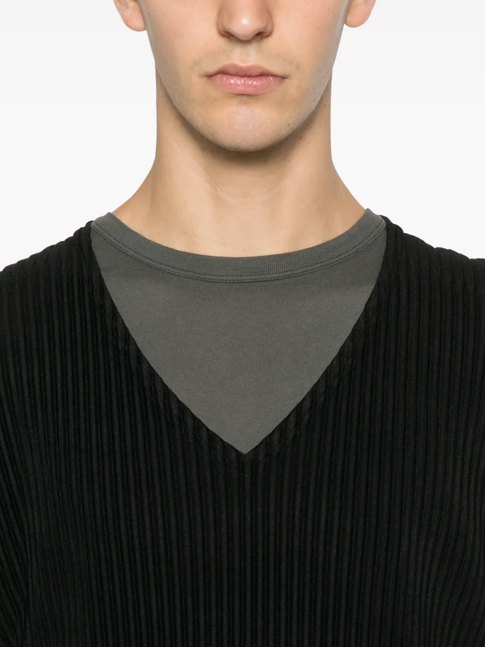 Close-up of the black plissé vest from Homme Plissé Issey Miyake on a white background.