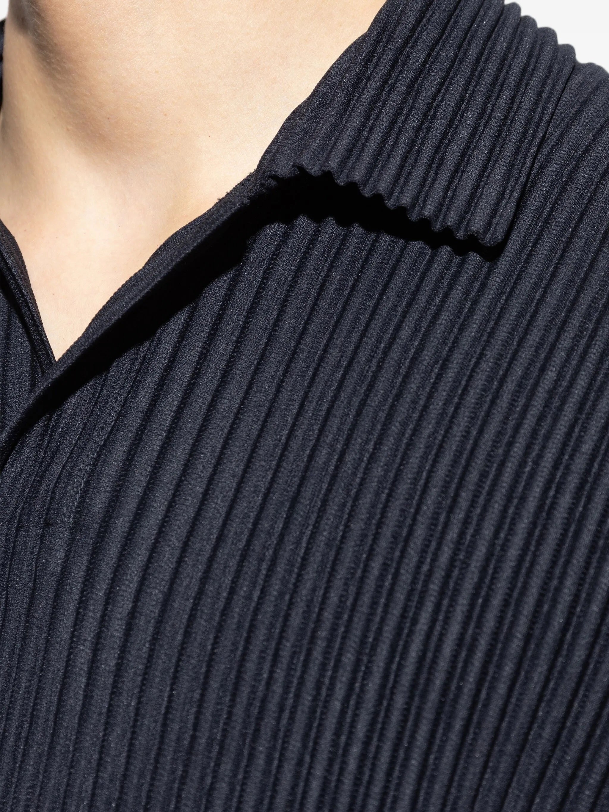 Close-up of a person wearing a dark ribbed polo