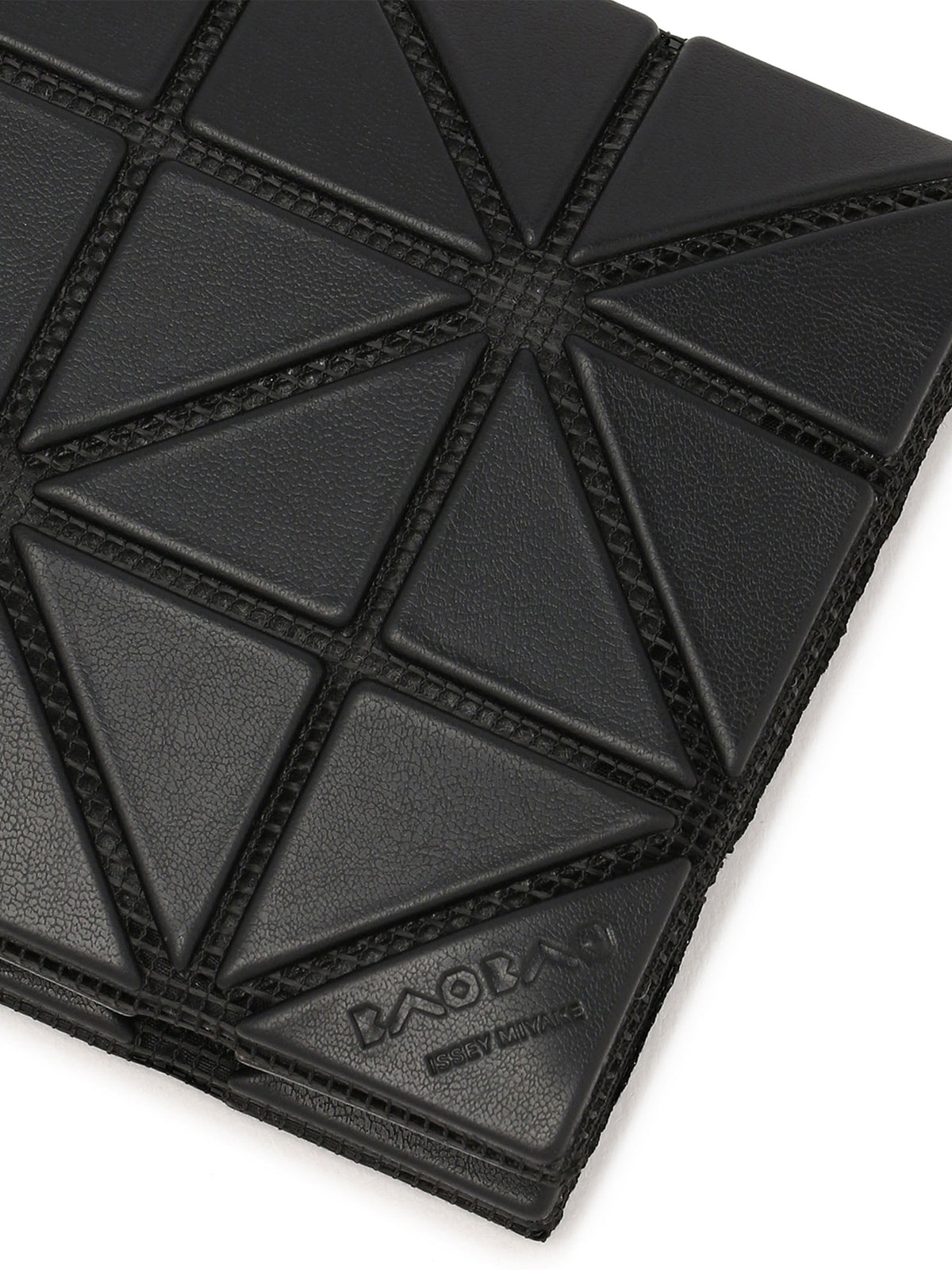 Close-up of the BAO BAO ISSEY MIYAKE card case showing the matte geometric surface, raised triangular panels and subtle embossed branding near the lower edge.