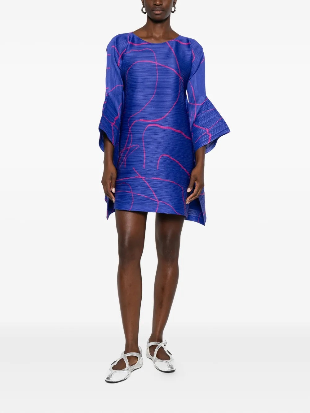 Woman wearing a blue dress with pink abstract patterns on a white background