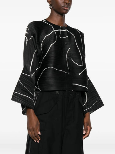 Black and white patterned top worn by a model on a white background