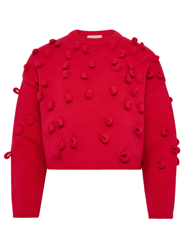Red sweater with pom-pom loops details on a white background