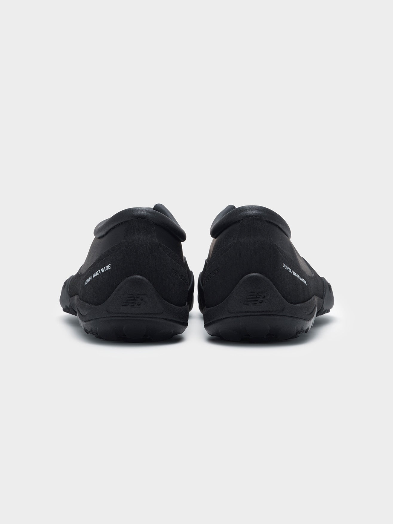 Junya Watanabe x New Balance MT10T sneakers in black, back view of pair, Junya Watanabe branding and New Balance heel logo