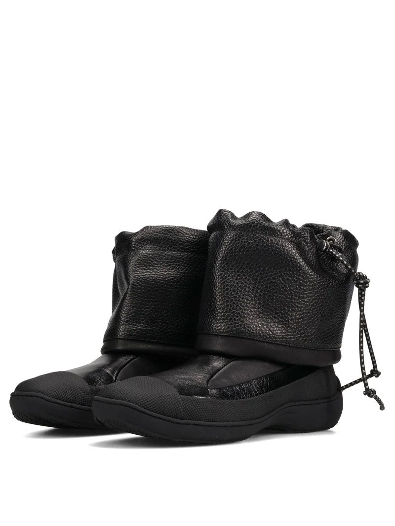 Kiko Kostadinov Avocet Leather Boots in Ink Black shown from a three-quarter angle, featuring the soft folded leather construction, rounded toes and substantial rubber soles.