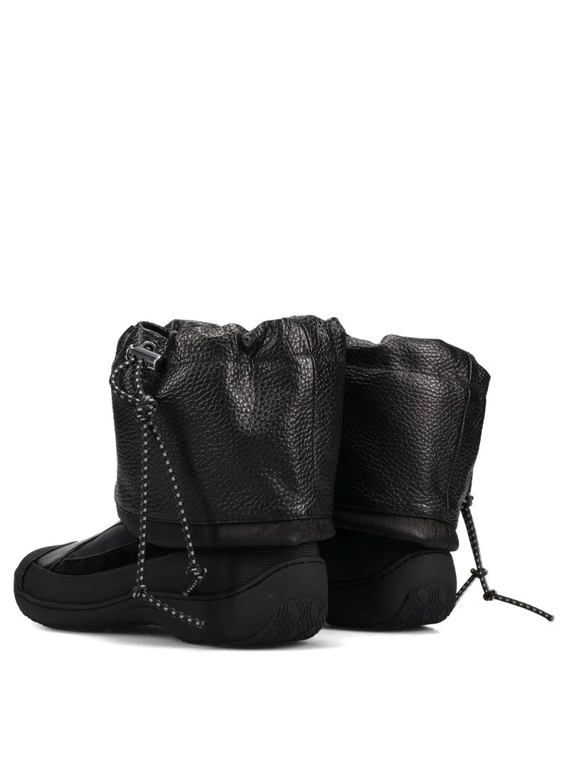 Rear three-quarter view of the Kiko Kostadinov Avocet Leather Boots in Ink Black, showing the gathered leather shafts, tonal construction and structured black soles.