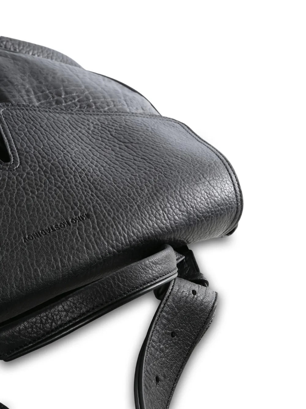 Close-up of the black leather messenger bag from Kiko Kostadinov with a top handle and adjustable shoulder straps on a white background