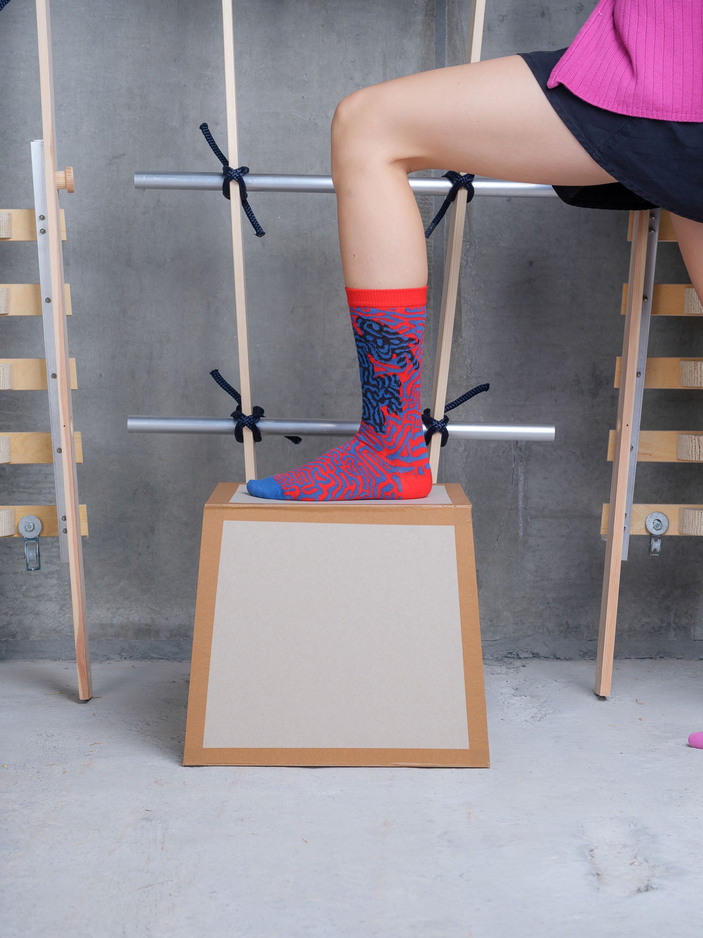 Model wearing Labyrinth Sock in Mandarin Blue Maze by Henrik Vibskov
