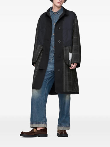Model wearing Maison Margiela black and grey check coat featuring an inside-out construction and front button closure