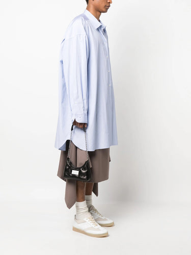 Model holding the Glam Slam Hobo Micro in Black by Maison Margiela, highlighting the padded design and adjustable metal chain shoulder strap.