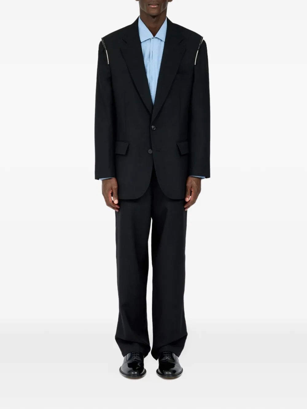 Male model wearing Maison Margiela Black Blazer, front view, single-breasted with shoulder details, two front pockets, and long sleeves.