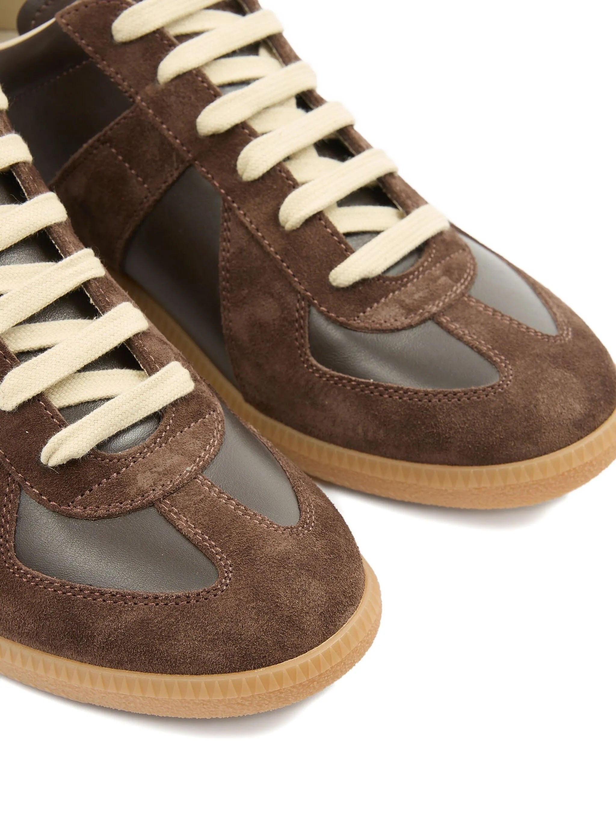 Brown suede sneakers with white laces on a white background