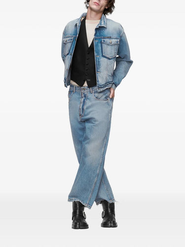 Front view of a model wearing the washed blue denim Maison Margiela sports jacket, showing the cropped fit, buttoned front, and worn denim texture.