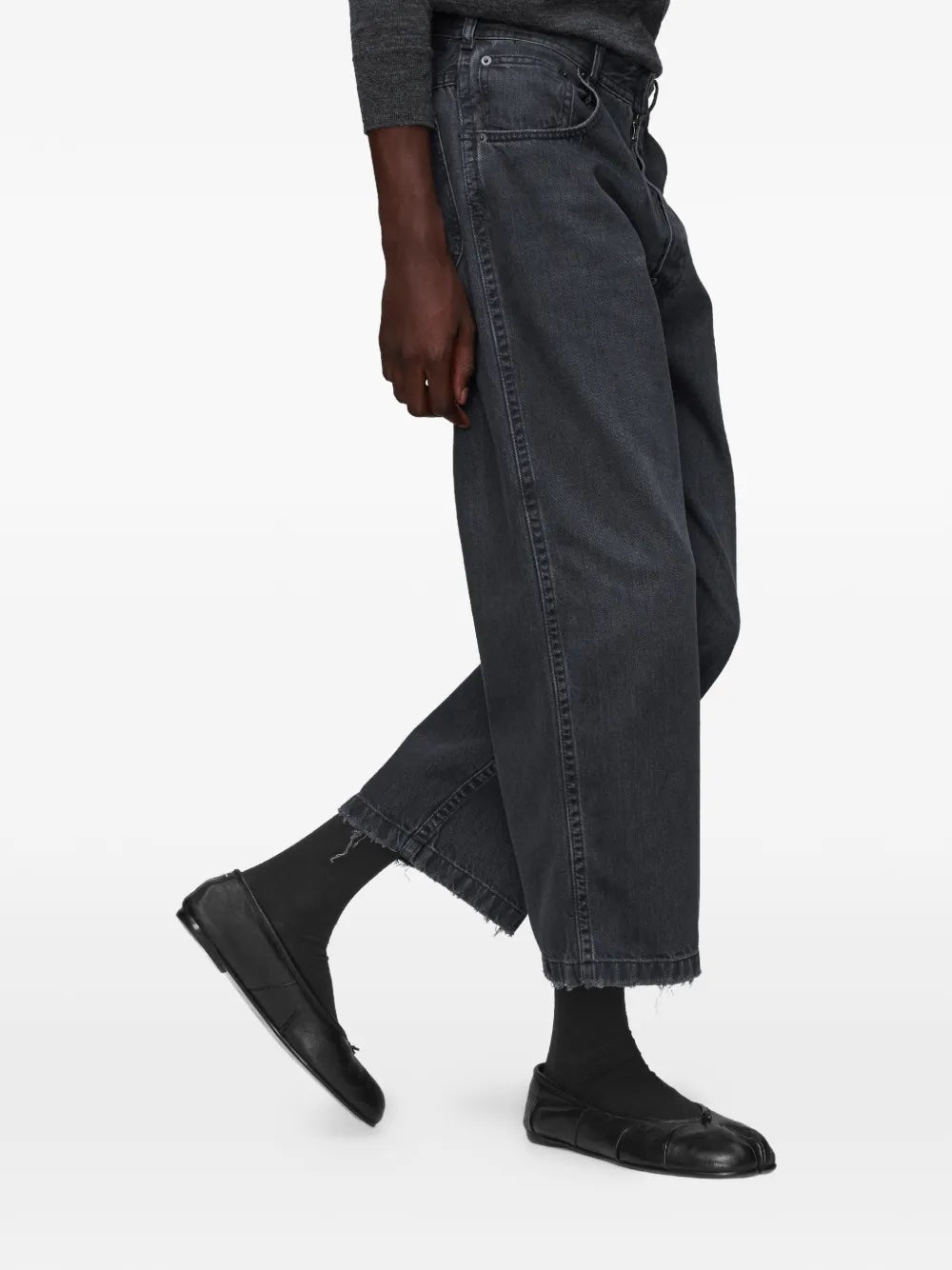 Close-up of model wearing the black washed denim jeans from Maison Margiela