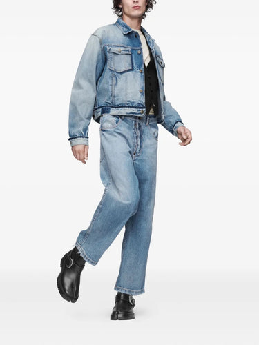 Front view of a male model wearing the Maison Margiela Pants 5 Pockets in Washed Blue, highlighting the relaxed straight-leg fit, raw-cut hem, and tailored five-pocket design.