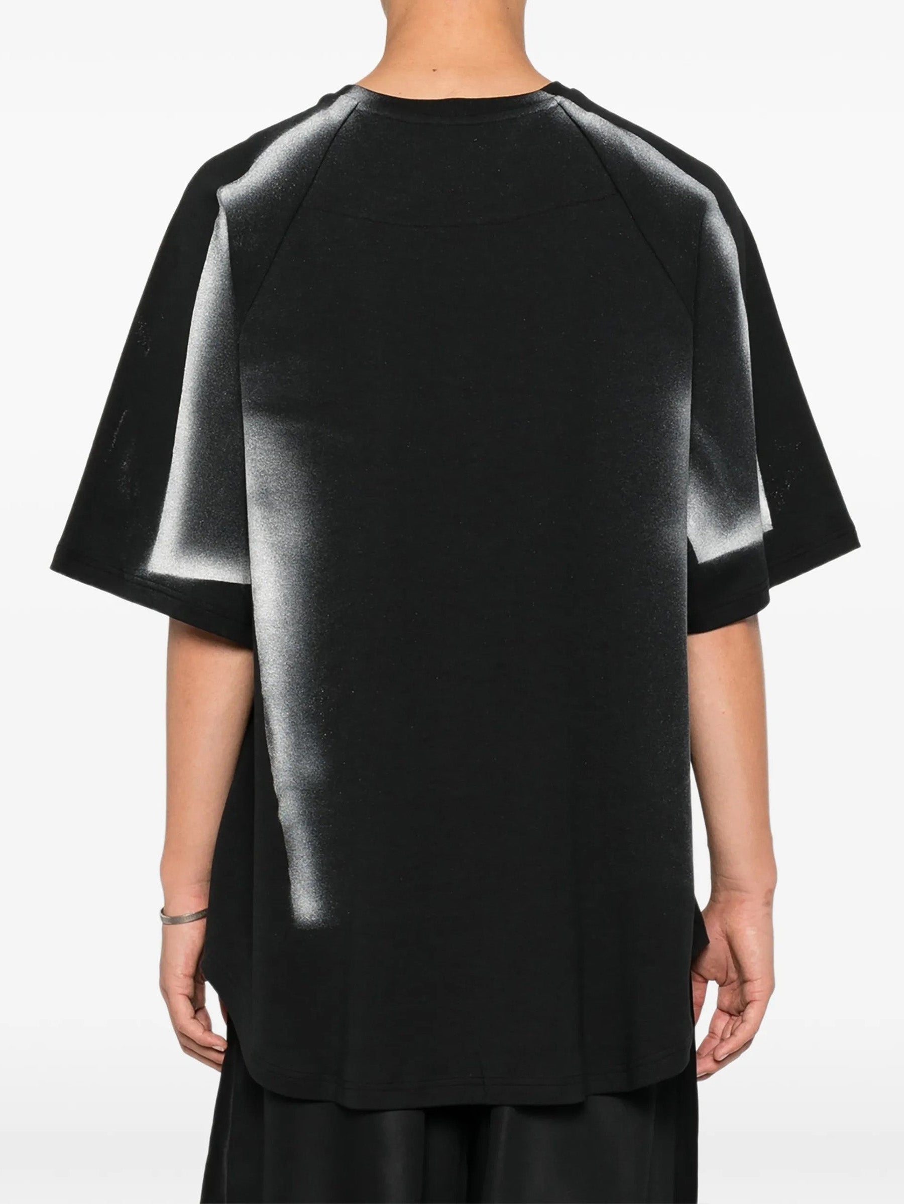 House Of The Very Islands Rae T-Shirt in Black Iridescent Print - three-quarter view on model showing raglan sleeves and oversized silhouette