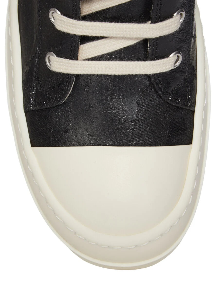 Close-up of Rick Owens DRKSHDW Tower Sneaks showing cracked black megacrust denim upper, cream laces, silver-tone eyelets and milk white rubber toe cap