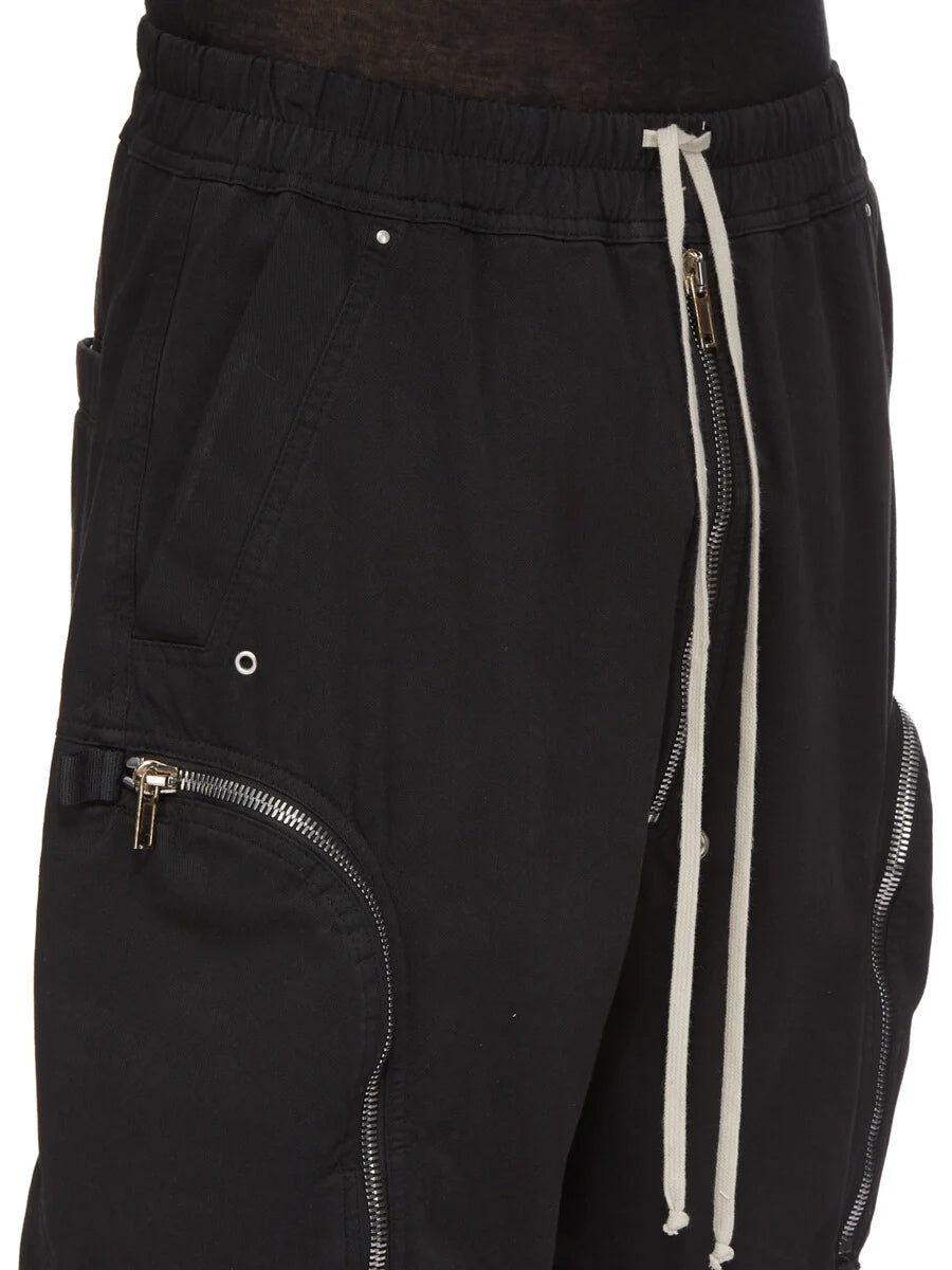Close-up of Rick Owens DRKSHDW Bauhaus Drawstring Shorts in Black showing the elasticated waistband, contrasting drawstrings, front zipper and metal eyelet details.