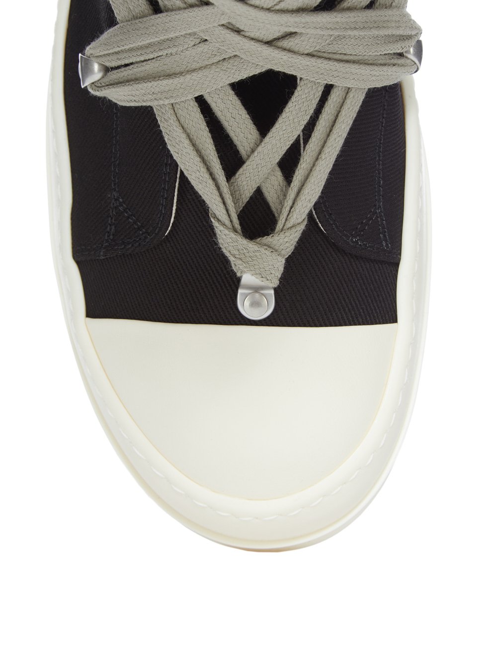 Close-up of a sneaker with white sole and black side panel on a white background