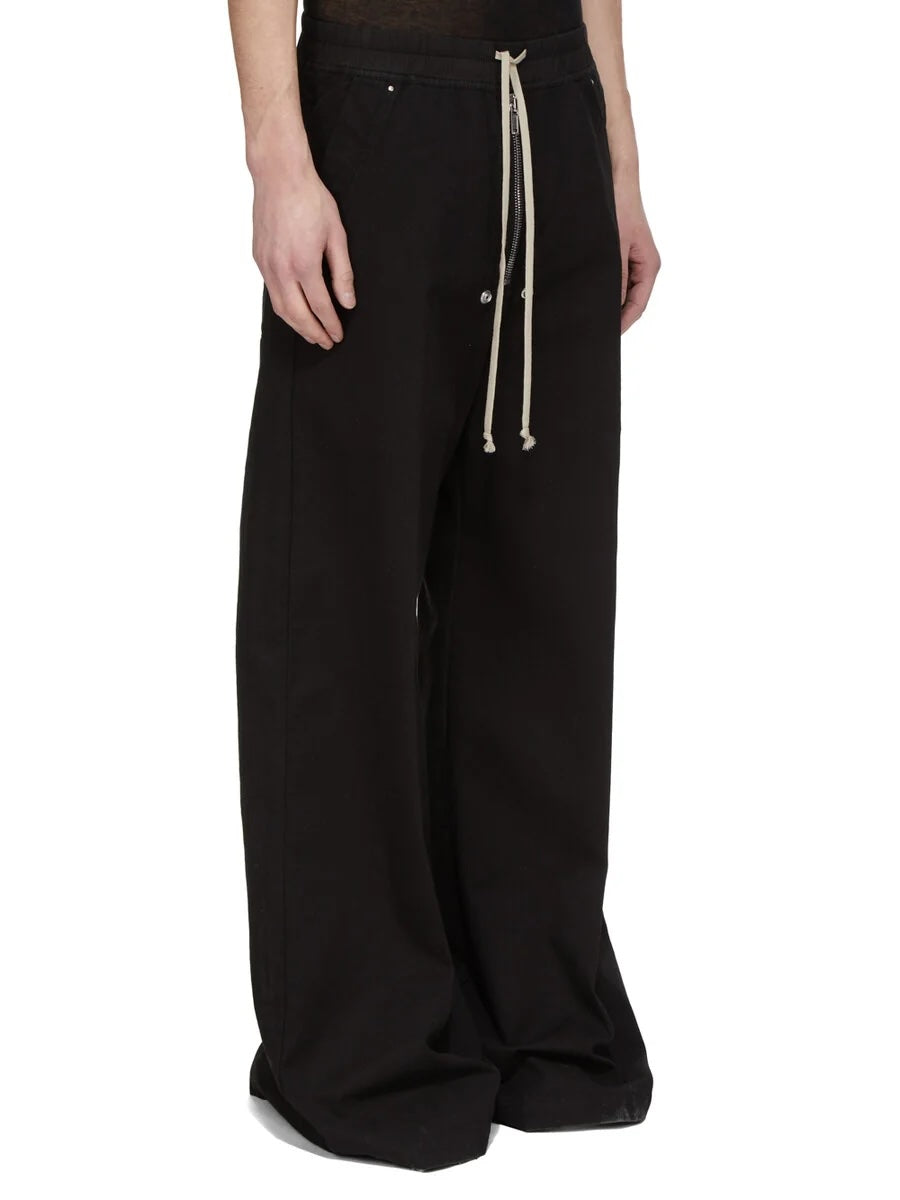 Rick Owens DRKSHDW Geth Belas in black shown on model from a front side angle with a low-crotch silhouette, wide legs and full-length drape.