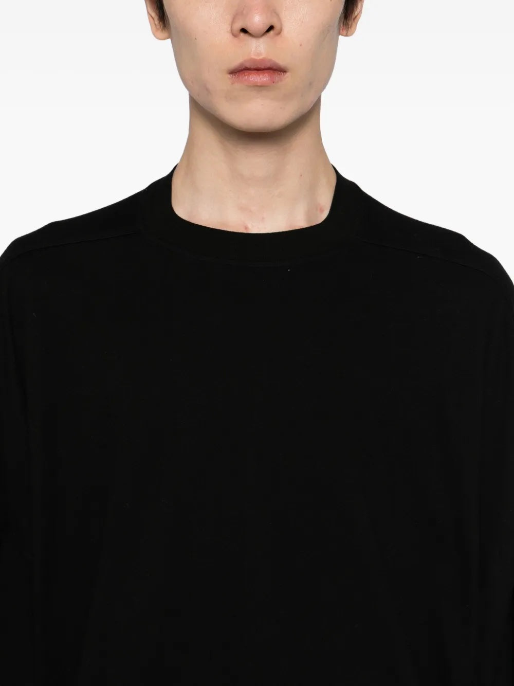 Person wearing a black oversized t-shirt from Rick Owens DRKSHDW against a white background