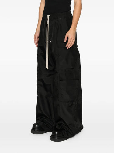 Side view of the black cargo pants with long drawstrings from Rick Owens DRKSHDW on a white background