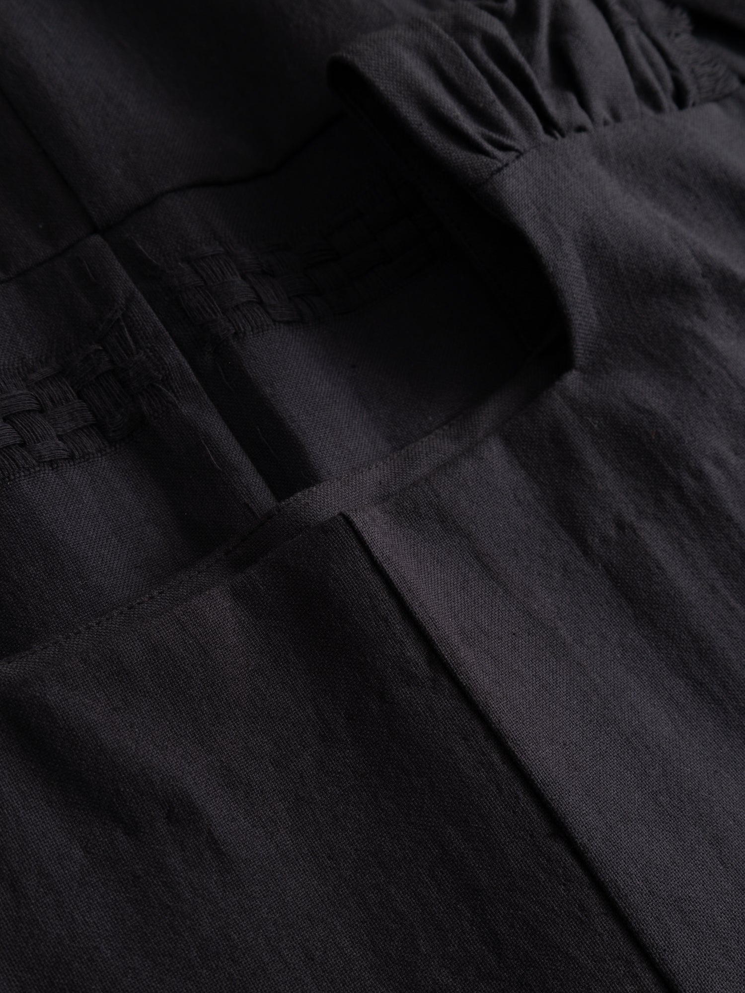 Stem Patchwork Dress in black, close-up of gathered waist seam, patch pocket and patchwork fabric construction detail