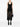 Person wearing a black sleeveless top and sheer black skirt on a white background