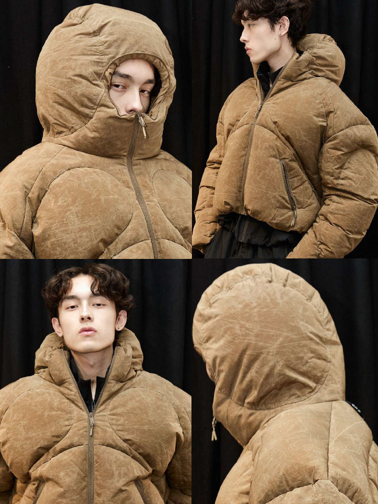 Stamm Exchange Anyone Puffer in Brown shown in a four-panel image with front, side and close-up views, highlighting the oversized quilted construction, cropped silhouette, zip pockets and voluminous padded hood.